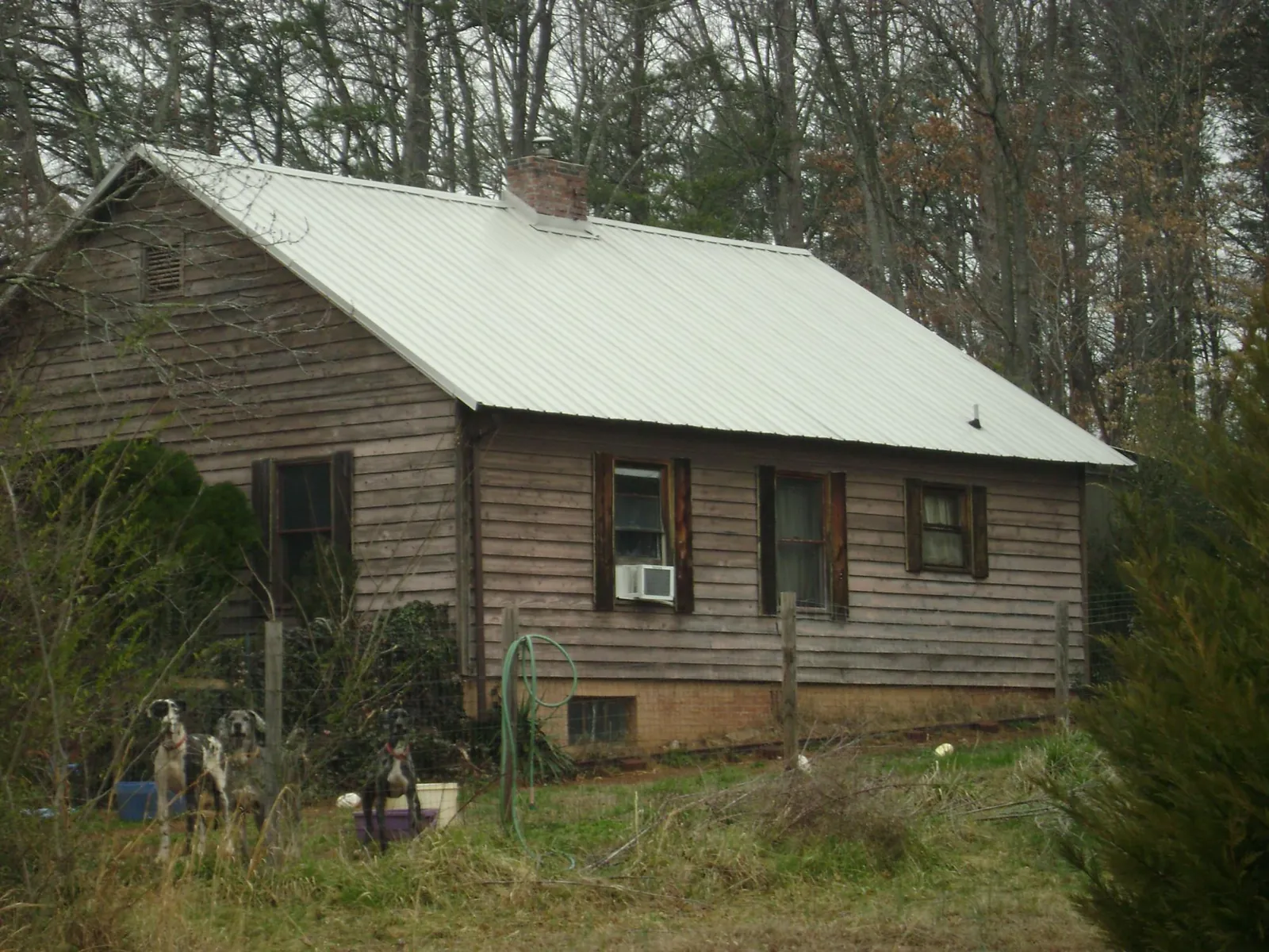 White metal roof on an old wood sided farmhouse, from a Metal Roof Installation job in Dunnellon